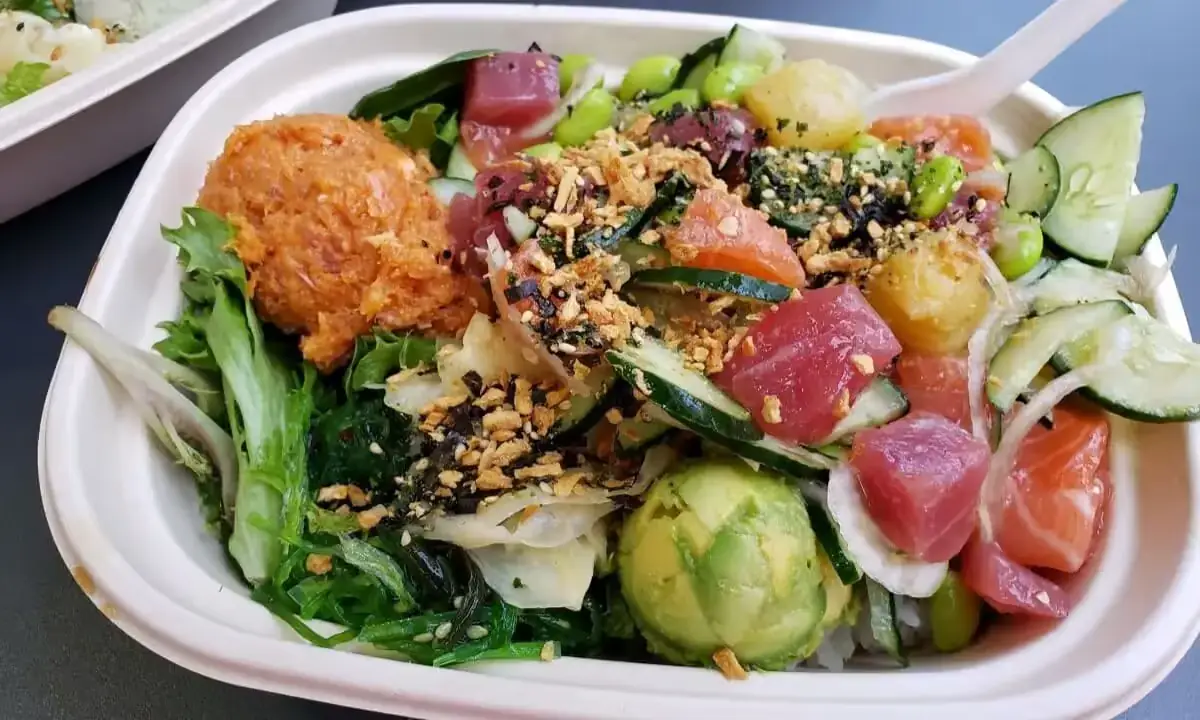 Assorted colorful poke bowls and vibrant salad options on a buffet table