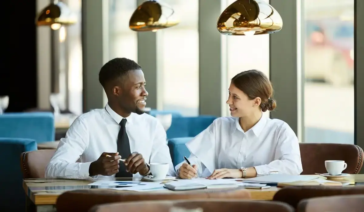 Prospective franchisee and advisor discussing franchise fit over paperwork in a restaurant